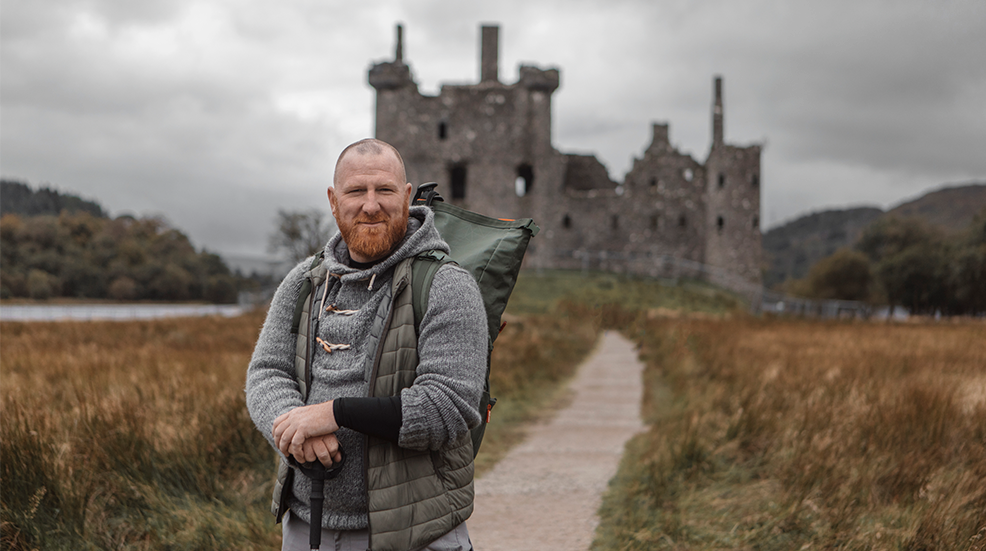 Male hiker enjoying the freedom of the single life outdoors at a ruined castle